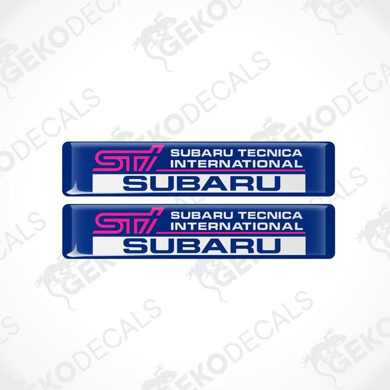 Two blue vinyl stickers with 'SUBARU TECNICA INTERNATIONAL STI ' text, featuring a pink and withe color scheme.