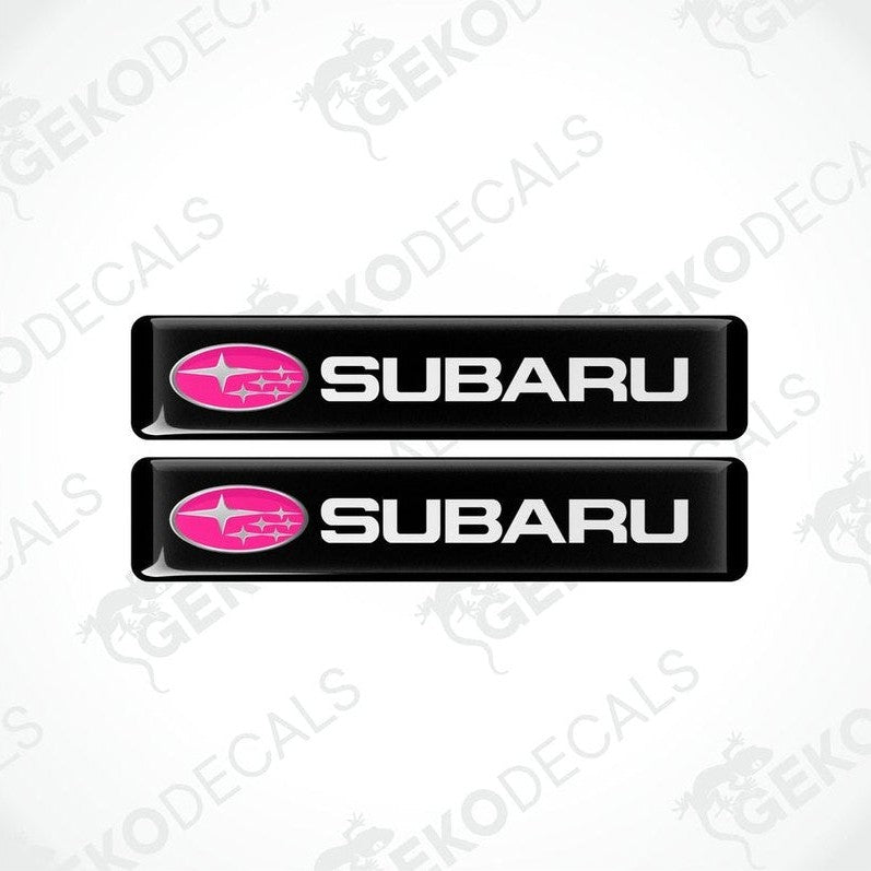 Two black vinyl stickers with the word 'SUBARU' written in white and a pink star symbol on each sticker.