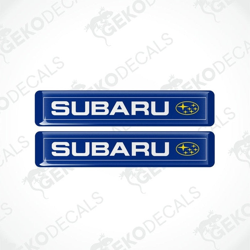 Two blue vinyl decals with the Subaru brand logo in white and yellow.