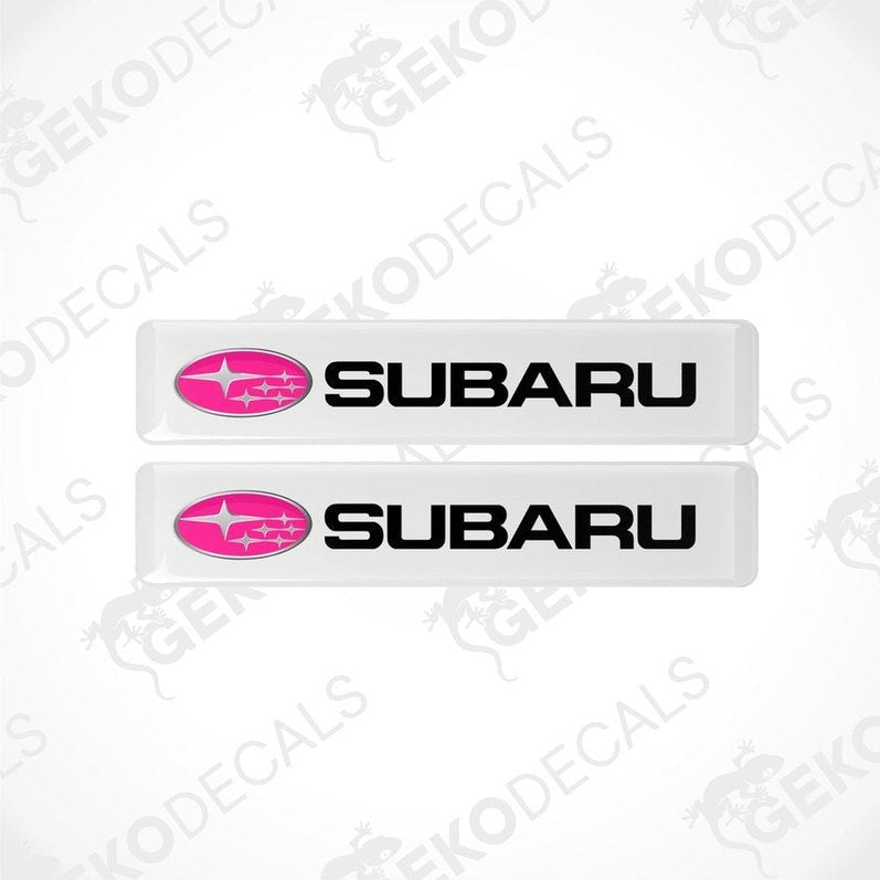 Two withe vinyl stickers with the word 'SUBARU' written in white and a pink star symbol on each sticker.