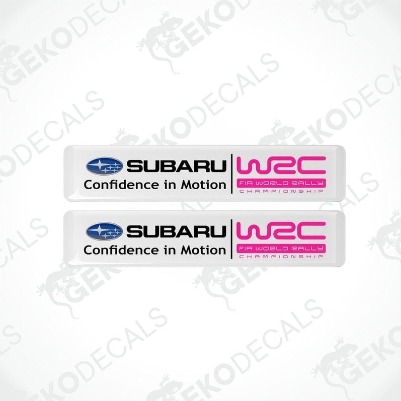 Two rectangular vinyl decals with a polyurethane coating featuring the Subaru logo and 'Confidence in Motion' slogan in pink and white colors.