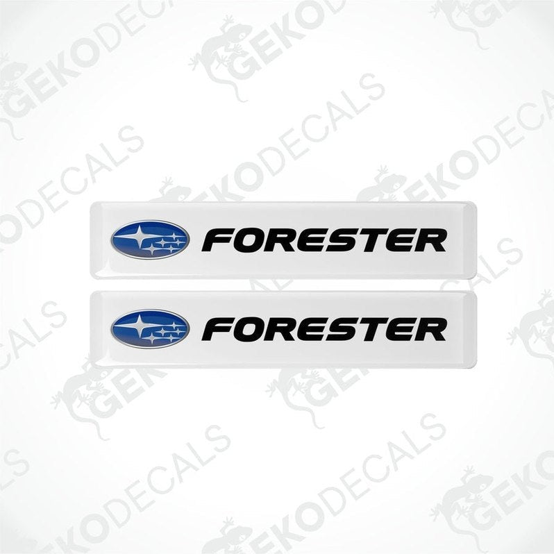 Two withe vinyl stickers with the word 'FORESTER' and a graphical representation of a car above the text.