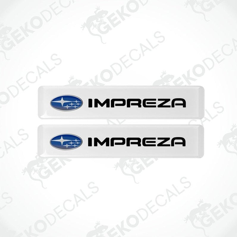 Two white vinyl stickers with the SUBARU IMPREZA brand logo printed on them.