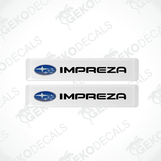 Two white vinyl stickers with the SUBARU IMPREZA brand logo printed on them.