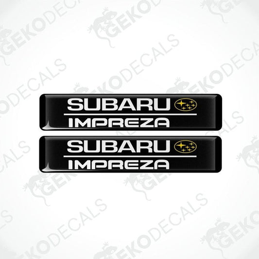 Two black decals with the Subaru car logo and the word 'SUBARU IMPREZA' in yellow letters.