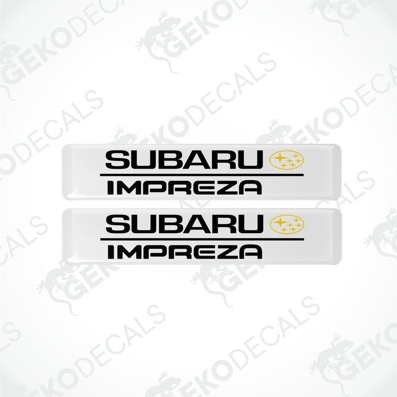 Two withe decals with the Subaru car logo and the word 'SUBARU IMPREZA' in yellow letters.
