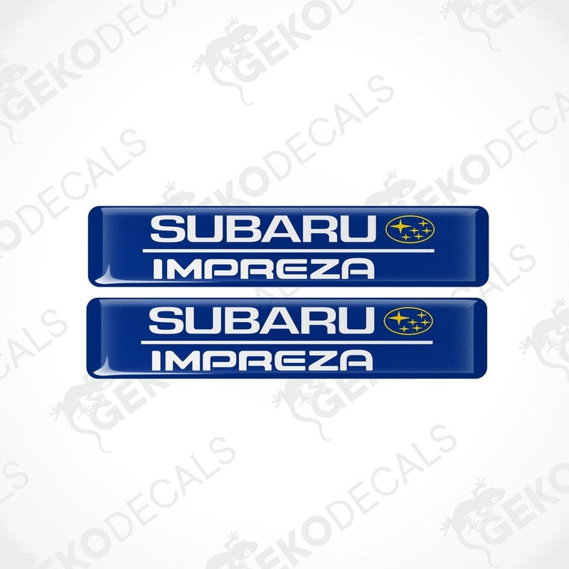Two blue decals with the Subaru car logo and the word 'SUBARU IMPREZA' in yellow letters.