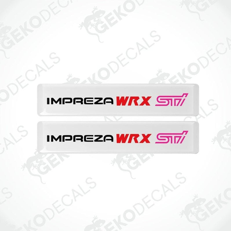 Two white vinyl stickers with the text 'IMPREZA WRX STI' in red and pink. The stickers are designed to be applied on a vehicle.