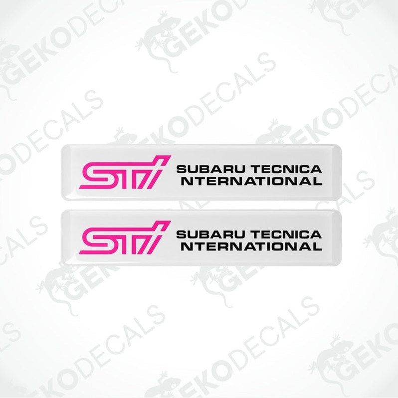 Two withe decals with pink and black text that read 'STI SUBARU TECNICA INTERNATIONAL'.