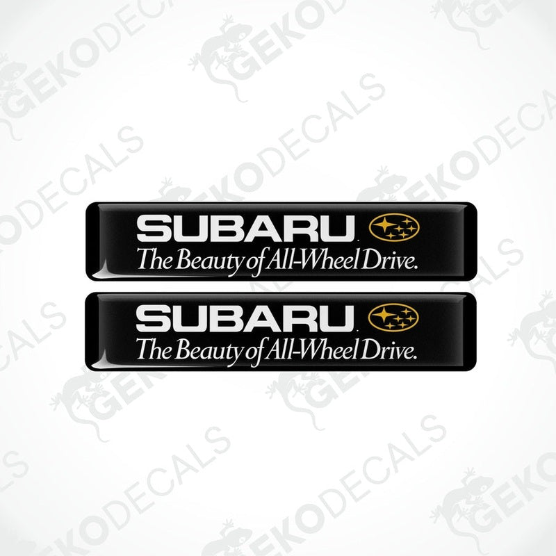 Two black rectangular decals with the Subaru logo and the text 'The Beauty of All-Wheel Drive'.
