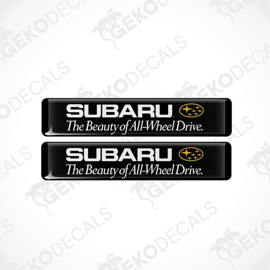 Two black rectangular decals with the Subaru logo and the text 'The Beauty of All-Wheel Drive'.