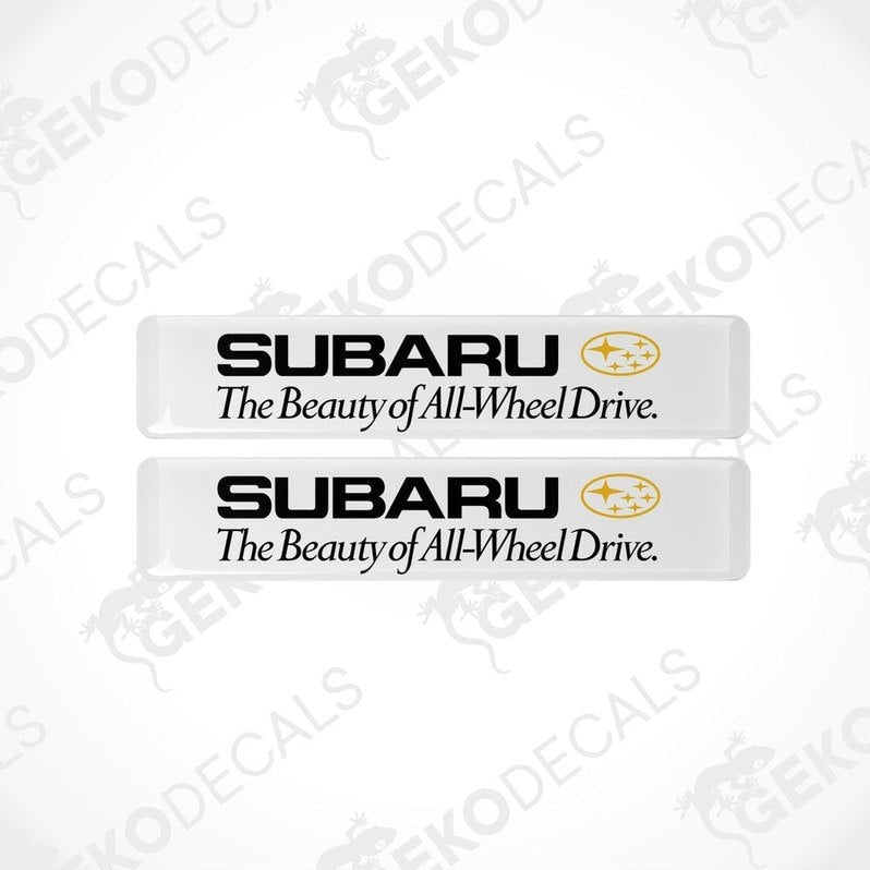 Two withe rectangular decals with the Subaru logo and the text 'The Beauty of All-Wheel Drive'.
