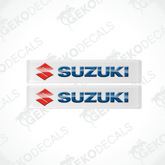 Two white vinyl stickers with the SUZUKI brand logo in blue and red.