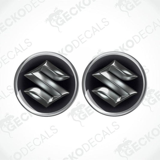 Two metallic Suzuki logos epoxy decals on a white background with 'Gecko Decals' branding.