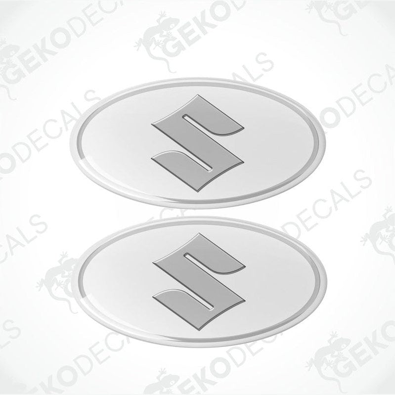 Two round white vinyl stickers with a silver 'S' logo for SUZUKI, with a visible GeckoDecals logo in the corner.