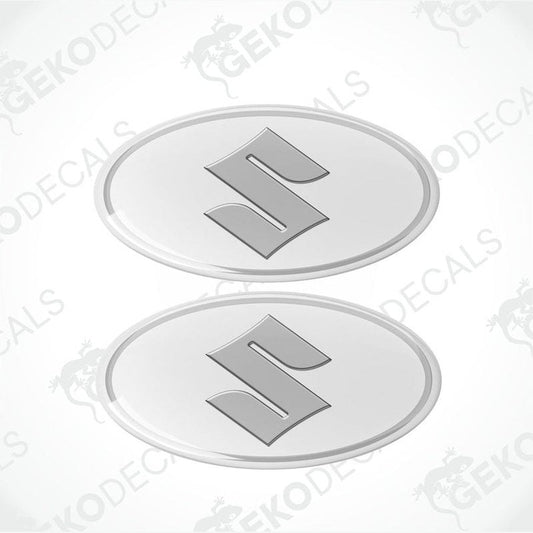 Two round white vinyl stickers with a silver 'S' logo for SUZUKI, with a visible GeckoDecals logo in the corner.