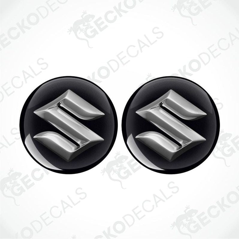 Two metallic Suzuki logos epoxy decals on a white background with 'Gecko Decals' branding.