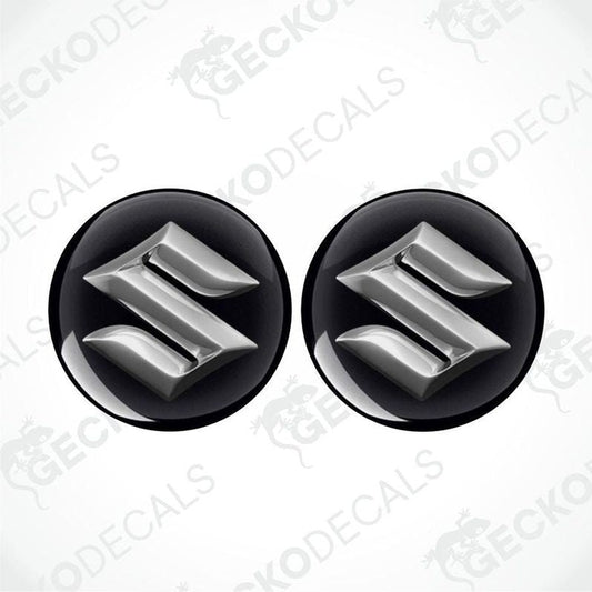 Two metallic Suzuki logos epoxy decals on a white background with 'Gecko Decals' branding.