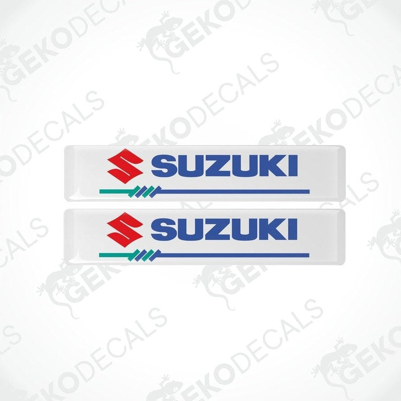 Two white vinyl stickers with the SUZUKI brand logo in blue and red.