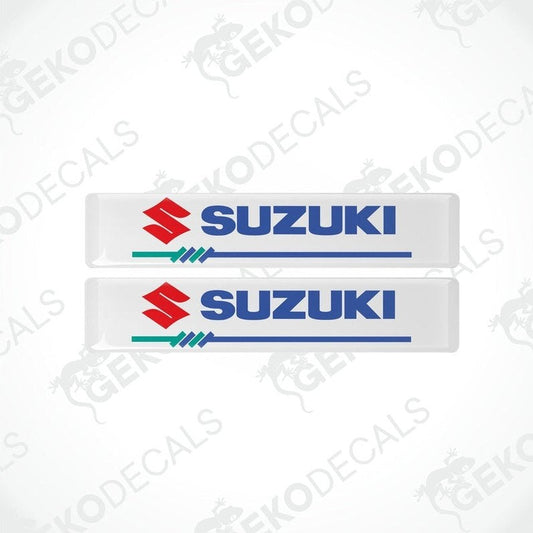 Two white vinyl stickers with the SUZUKI brand logo in blue and red.