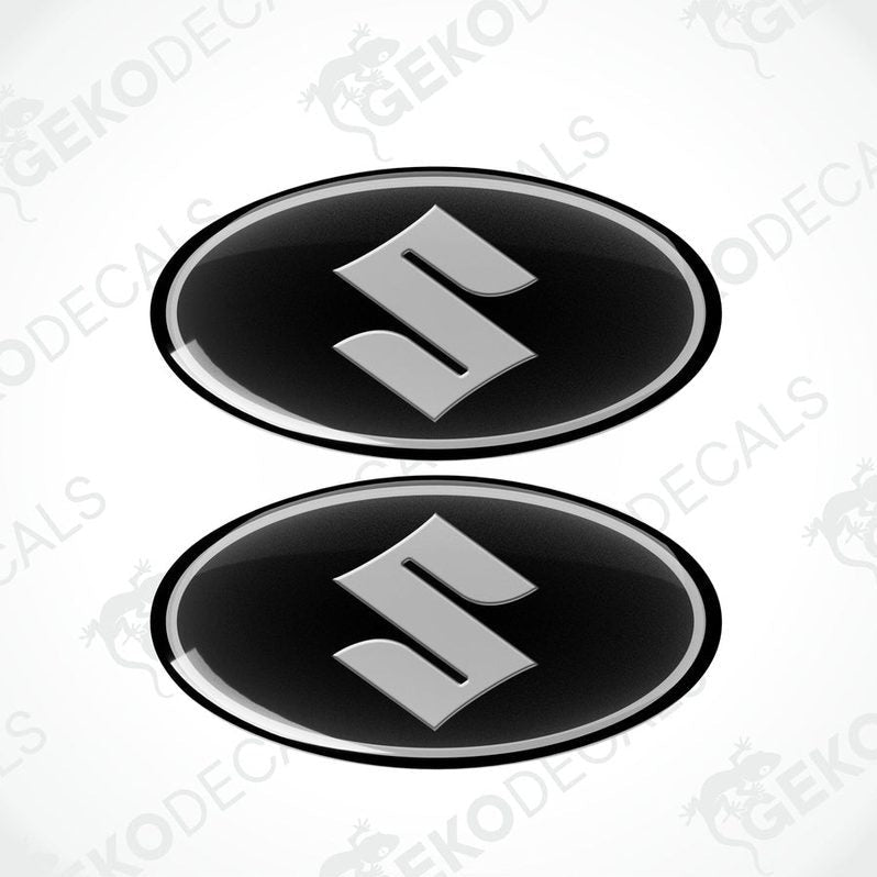 Two round black vinyl stickers with a silver 'S' logo for SUZUKI, with a visible GeckoDecals logo in the corner.