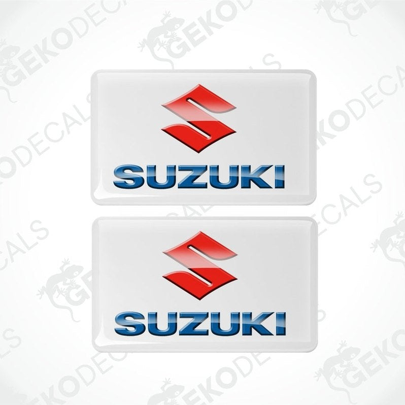 Two withe vinyl stickers with the SUZUKI logo in blue and red.