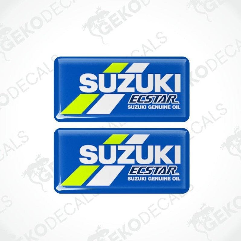 Two blue vinyl stickers with the text 'SUZUKI ECSTAR GENUINE OIL' and a logo depicting a stylized tire and the Suzuki logo in white and green.
