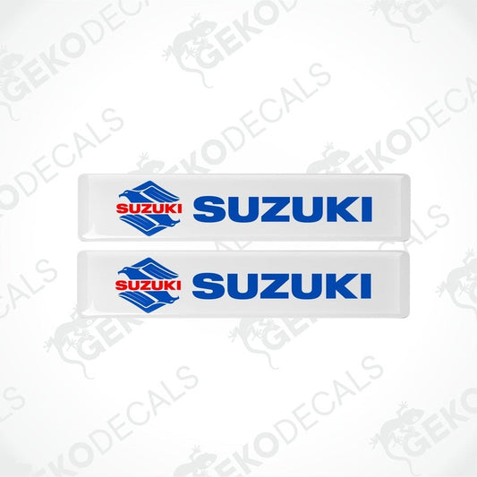 Two white vinyl stickers with the SUZUKI brand logo in blue and red.