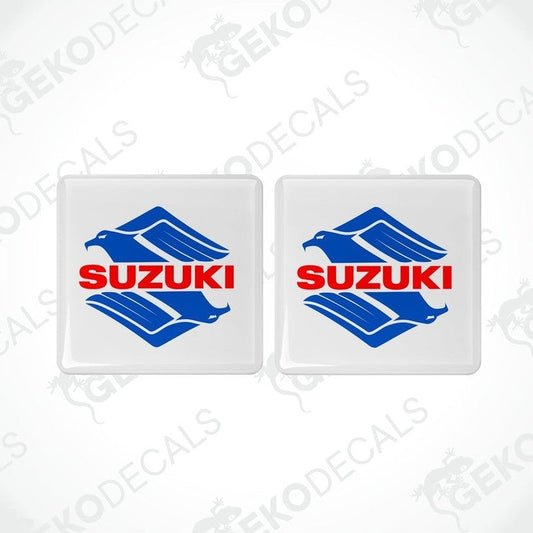Two white square stickers with the SUZUKI brand logo in blue and red.