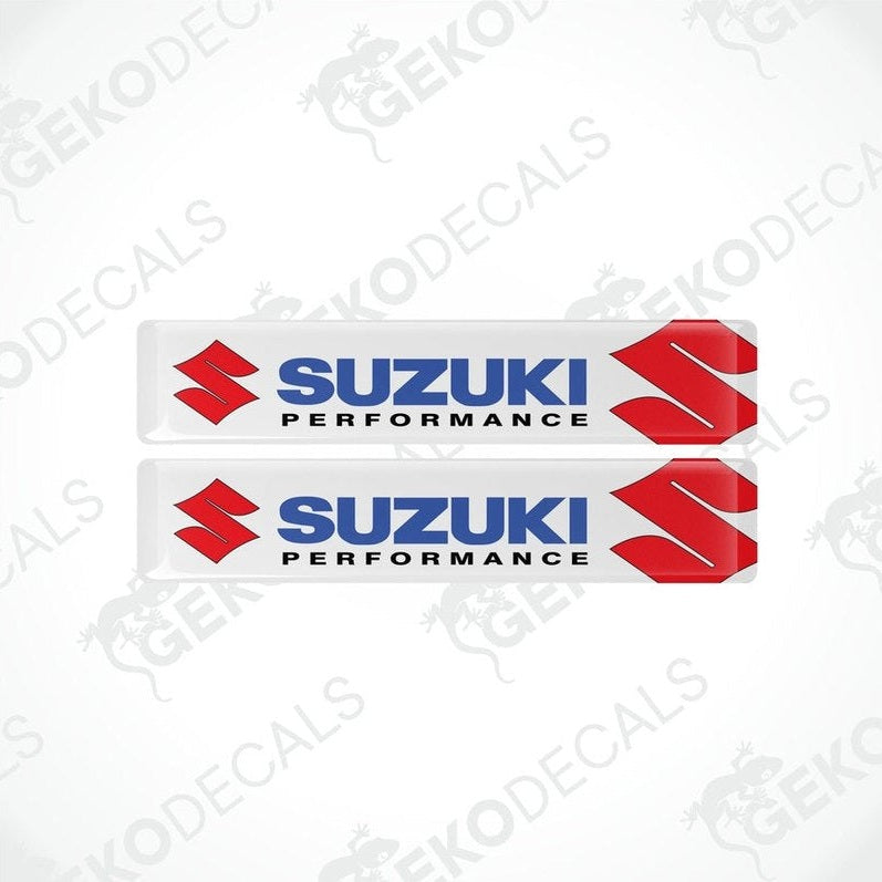 Two rectangular withe vinyl decals with the 'Suzuki Performance' logo in red and black.