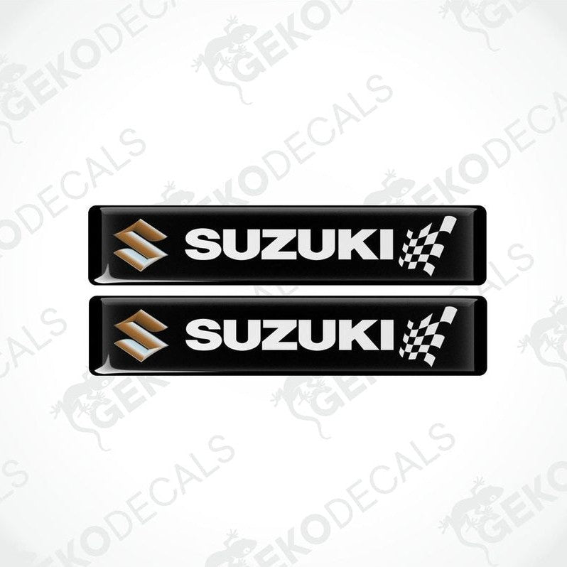 Two black rectangular vinyl decals with the SUZUKI brand logo and checkered flag design.