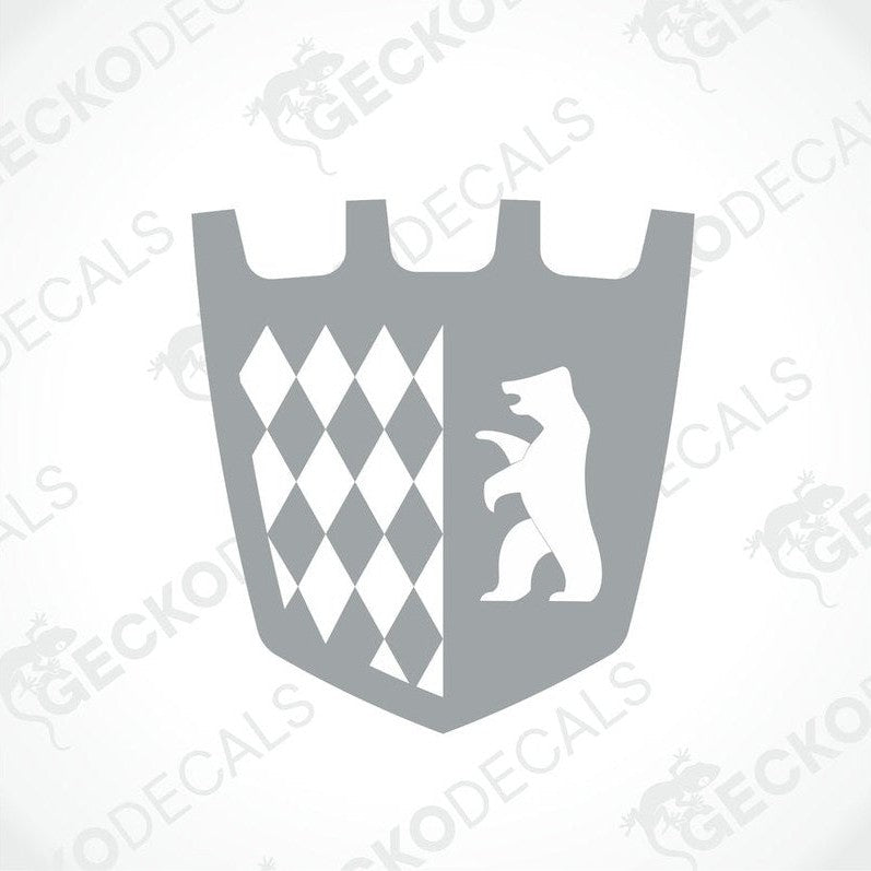A gray die cut sticker with a shield design, featuring a bear and a checkered pattern, delivered on transfer paper.