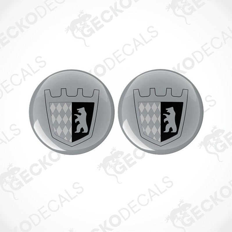 Two round silver epoxy decals with a black design, likely to be placed on a motorhome.