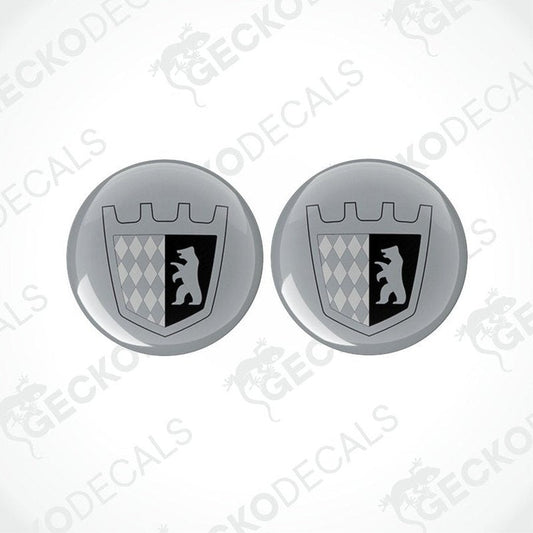 Two round silver epoxy decals with a black design, likely to be placed on a motorhome.