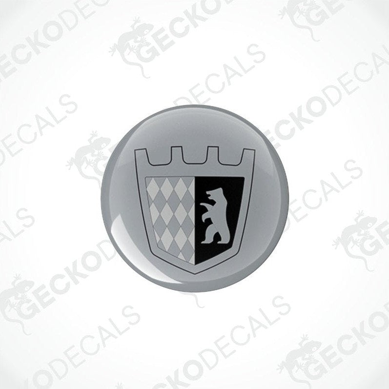 Two round silver epoxy decals with a black design, likely to be placed on a motorhome.