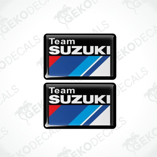 Two vinyl stickers with a TEAM SUZUKI design, featuring red, blue, white, and black colors and the Suzuki logo.