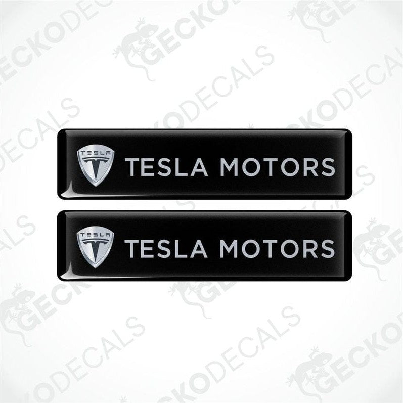 Two black Tesla Motors decals on a white background