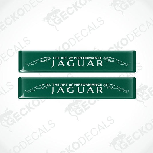Two rectangular green car decals with white text that reads 'THE ART OF PERFORMANCE JAGUAR'.
