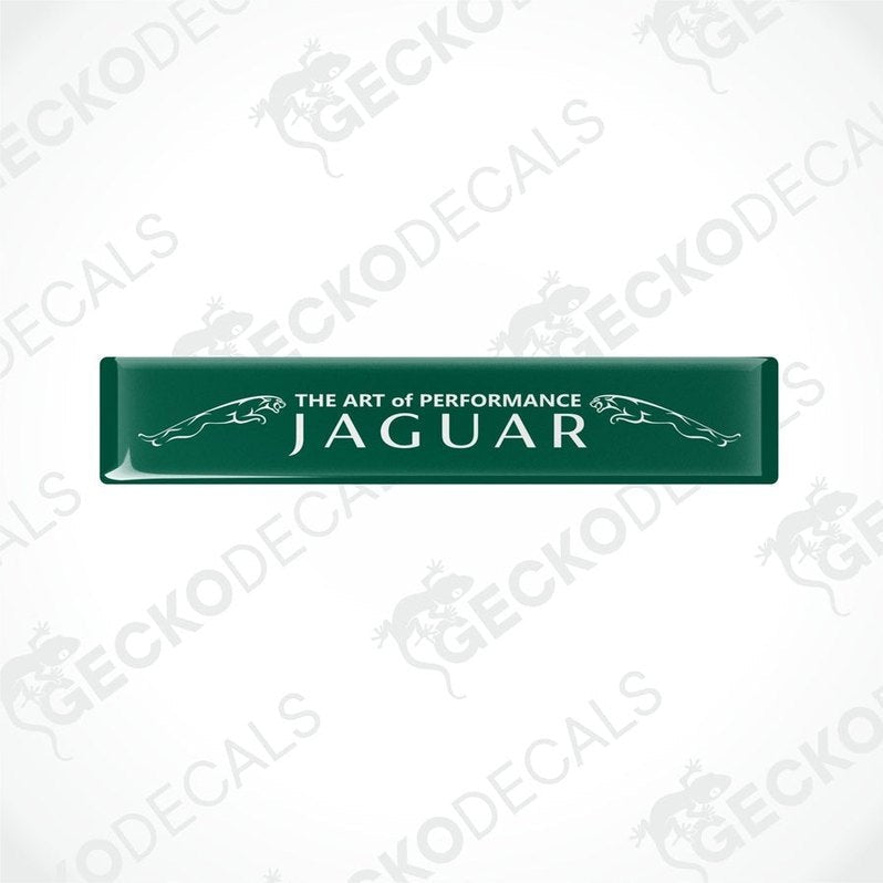 Rectangular green car decals with white text that reads 'THE ART OF PERFORMANCE JAGUAR'.