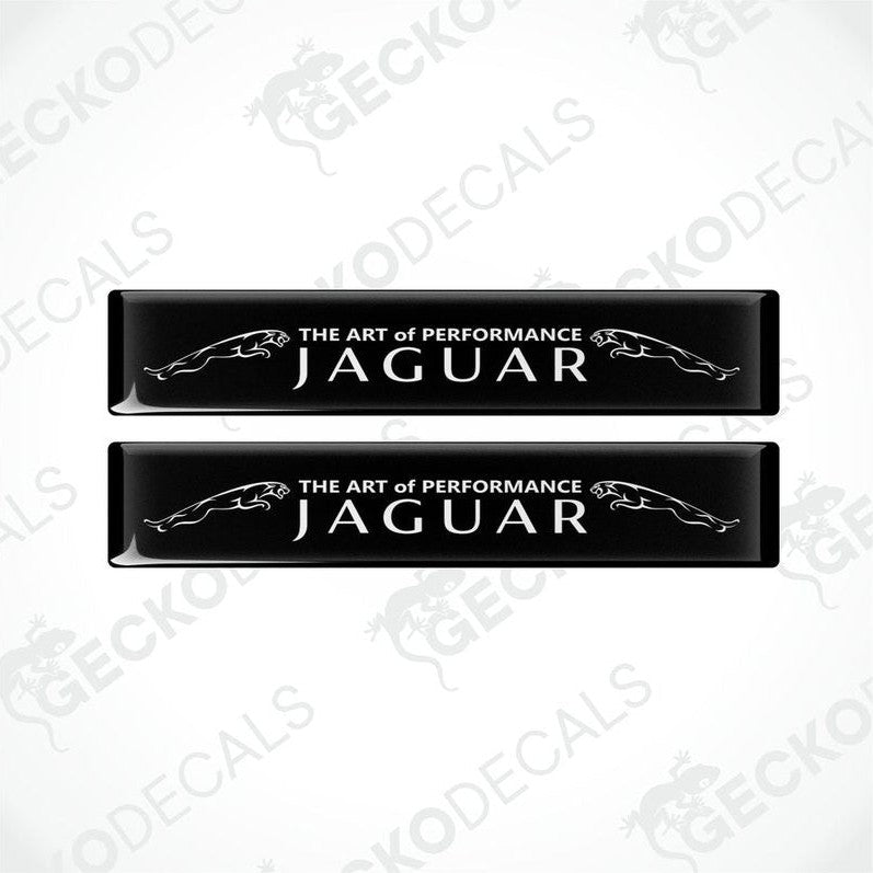 Two rectangular black car decals with white text that reads 'THE ART OF PERFORMANCE JAGUAR'.