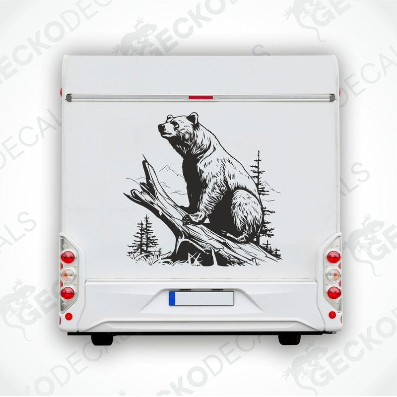 A black and white die cut sticker of a bear sitting on a stump, positioned on the side of a white vehicle.