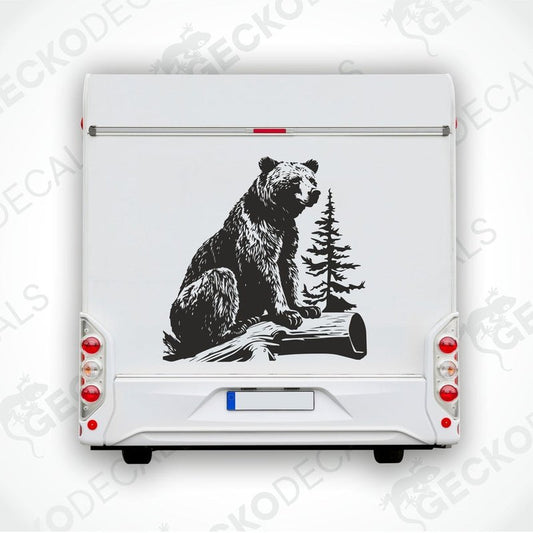 A die cut sticker of a bear sitting on a stump, intended for use as a car decal or sticker.