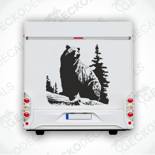 A die cut sticker of a black bear sitting on a stump with a forest backdrop, delivered on transfer paper.