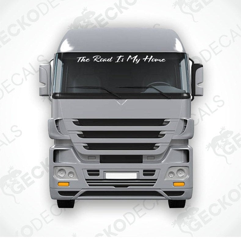 A windscreen decal with the text 'The Road Is My Home' displayed on the front of a gray truck.