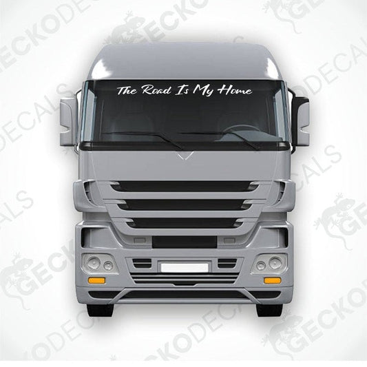 A windscreen decal with the text 'The Road Is My Home' displayed on the front of a gray truck.