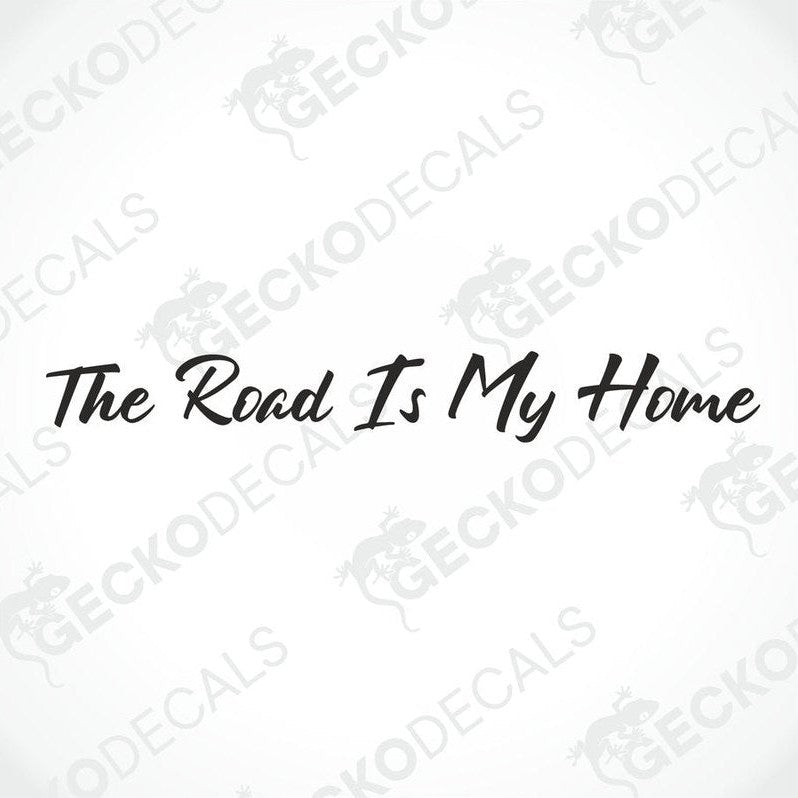 A windscreen decal with the text 'The Road Is My Home' displayed on the front of a gray truck.