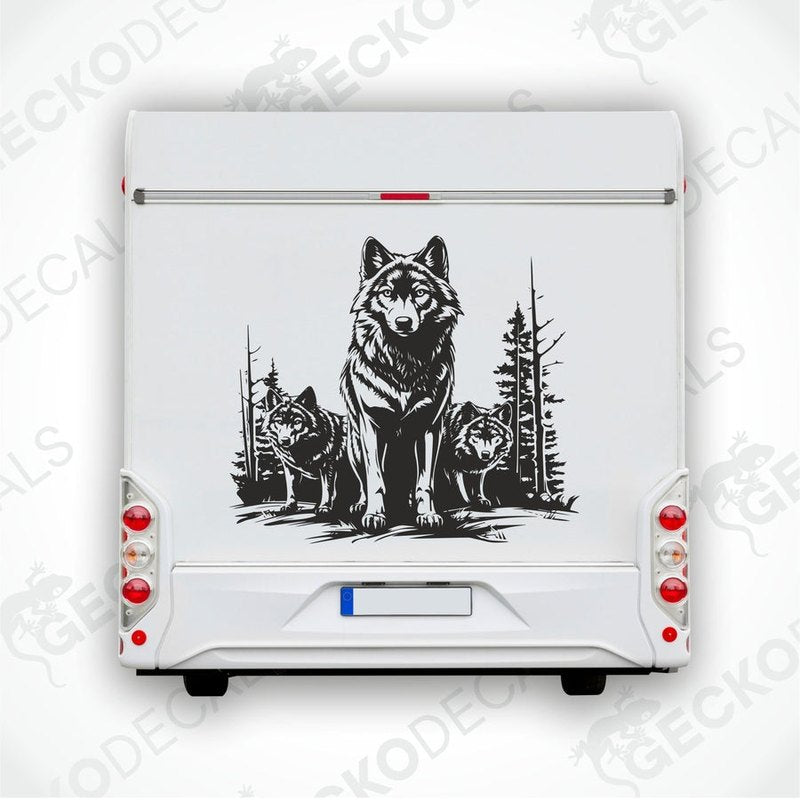 A black decal of three wolves in a forest setting, positioned on the rear of a white vehicle.