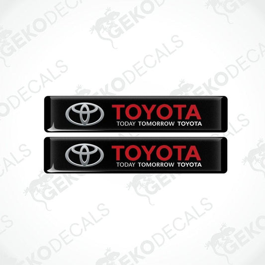 Two black vinyl stickers with the Toyota logo and the text 'TODAY TOMORROW TOYOTA' printed on them.