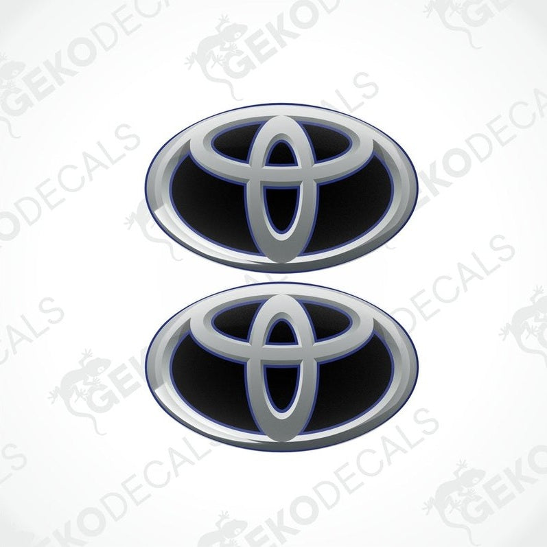 Two blue and silver Toyota branded vinyl stickers with a dome shape and a polyurethane coating.
