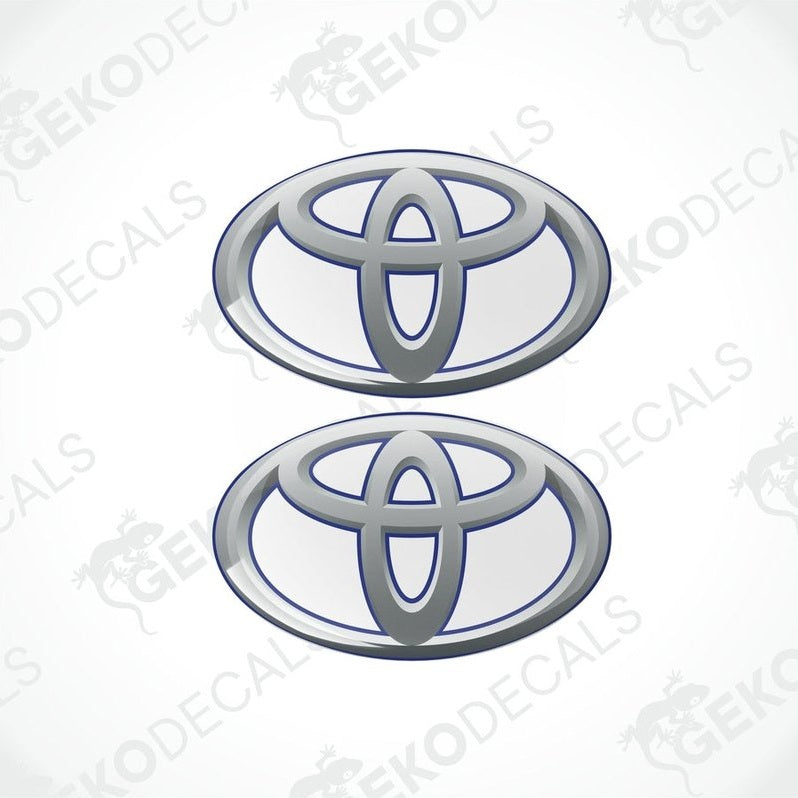 Two blue and silver Toyota branded vinyl stickers with a dome shape and a polyurethane coating.